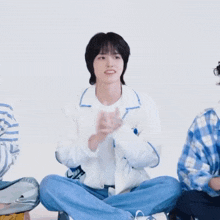 a group of young men are sitting on the floor with their legs crossed and applauding