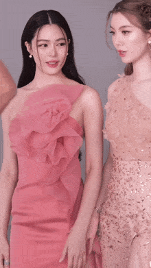 two women are standing next to each other and one is wearing a pink dress