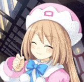 a girl wearing a pink hat with an o on it smiles