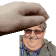 a hand is holding a picture of a man 's head and smiling .