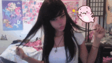 a girl with long black hair is standing in front of a wall with posters of ponies on it