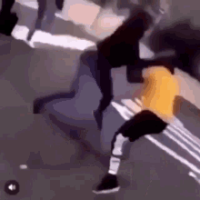 a man in a yellow shirt is fighting another man in a black shirt on the side of the road .