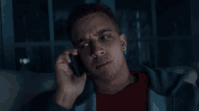 a man sitting on a couch talking on a cellphone