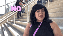 a woman stands on a set of stairs and says " no "