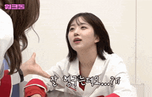a woman in a lab coat talks to another woman