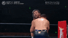 a man in a wrestling ring with a iwc logo on his shirt