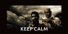 a man with a beard is standing next to another man with the words `` keep calm '' written on it .