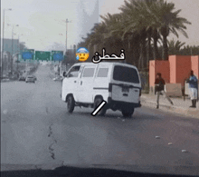 a white van is parked on the side of the road with arabic writing on it