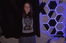 a woman with red hair is standing in front of a black curtain and a wall with lights on it