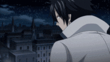 a man in a white coat stands in front of a cityscape at night