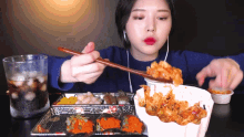 a woman is eating food with chopsticks and a glass of soda
