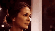 a close up of a woman 's face with a bun .
