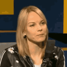 a woman is sitting in front of a microphone and looking at the camera .