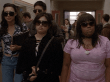 a woman wearing sunglasses and a pink shirt with lips on it