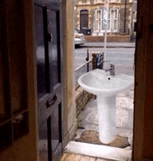 a white pedestal sink is outside of a building