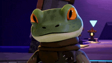 a green frog with orange eyes is wearing a scarf around its neck