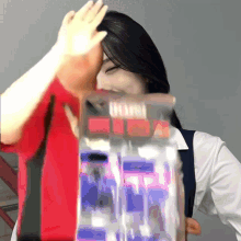 a woman in a red shirt is holding a bag that says ' eee ' on it