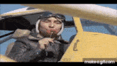 a man in a helmet is holding a lollipop in his mouth