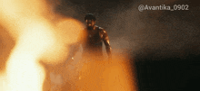 a man standing in front of a fire with the hashtag avantika_0902 on the bottom
