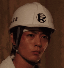 a man wearing a white hard hat with chinese writing