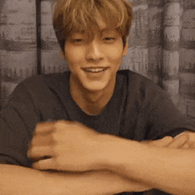 a man with his arms crossed is smiling and looking at the camera
