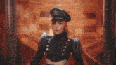 a woman in a military uniform with a star on her hat is standing in front of a mirror .