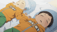 two baby boys laying on a bed wearing jackets that say baby on them