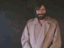 a man with glasses and a beard is making a funny face .
