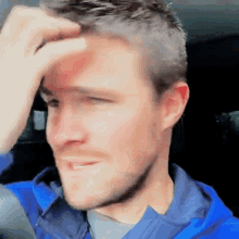 a close up of a man 's face with his hand on his forehead .