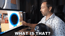 a man sitting in front of a computer with the words " what is that " on the bottom