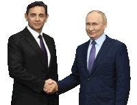 a man in a suit and tie shakes hands with another man in a suit