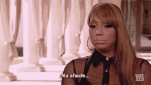 a woman is sitting in front of a row of white columns and says `` no shade '' .