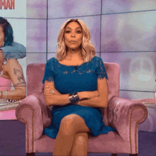 a woman in a blue dress is sitting in a pink chair