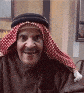 a man wearing a hat and a head scarf smiles