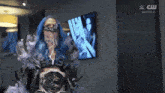 a woman with blue hair is wearing a mask and holding a wrestling championship belt .