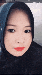 a close up of a woman wearing a hijab with the time of 12:33