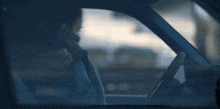 a man with a beard is driving a car and talking on a cell phone