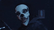 a man wearing a skull mask is holding a knife