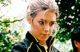 a close up of a woman wearing a black and yellow jacket