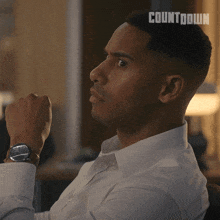 a man wearing a white shirt and a watch has the word countdown written on his head
