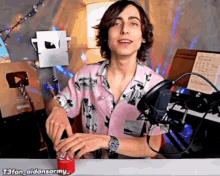 a young man in a pink shirt is holding a coke can