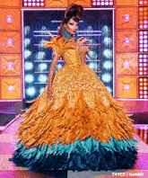 a drag queen is wearing a yellow and blue feathered dress on a stage .