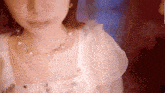 a close up of a woman wearing a necklace with pearls
