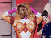 a drag queen is holding her hair while another drag queen stands behind her
