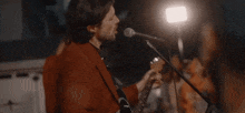 a man in a red suit sings into a microphone