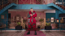 a man in a red jacket is dancing in a room with a netflix logo on the bottom