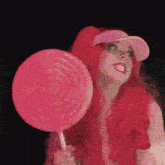 a woman with red hair holds a pink lollipop