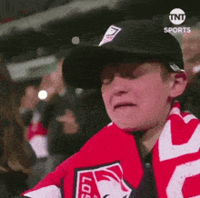 a young boy wearing a hat and scarf with los angeles written on it