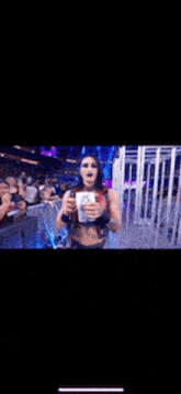 a woman with blue hair is covering her face with her hand while standing in front of a crowd .
