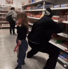 a woman is standing in front of a shelf that has a sticker that says ' snickers ' on it